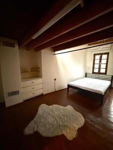 Un dormitorio con una cama y una alfombra en el suelo. en 3-Story Bohemian Greek House w Garden, en Ayvalık