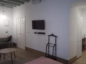 un soggiorno con TV su una parete bianca di La Fuente Apartamento Jerez a Jerez de la Frontera