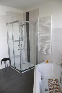 a bathroom with a glass shower and a tub at Jürgen Ferienwohnung in Wernigerode