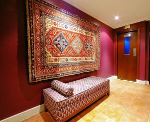 un grande tappeto appeso a un muro accanto a un divano di Monaco Hotel a Dubai