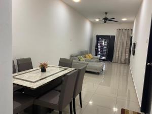 a living room with a dining table and a couch at Desa Murni Homestay in Kuantan
