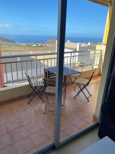 ein Balkon mit Tisch und Stühlen und dem Meer in der Unterkunft Apartamento Grosso in Chayofa