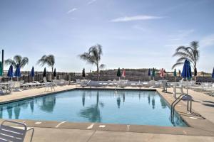 ein großer Swimmingpool mit Stühlen und Palmen in der Unterkunft Waterfront Cottage with Private Dock in Ocean Pines! in Ocean Pines