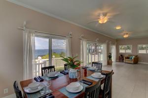 a dining room with a table and a view of the ocean at Paradise Ocean View in Keaau