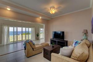 a living room with a couch and a tv at Paradise Ocean View in Keaau