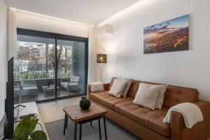 a living room with a brown couch and a tv at With pool in Funchal - Acqua Residence V in Funchal