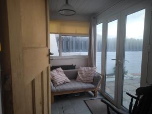 a living room with a couch and a large window at Seaside Retreat Guest Suite - Encil ger y môr in Aberystwyth