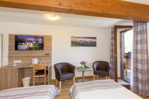 a hotel room with two beds and a desk at Gästehaus Funk in Bad Feilnbach