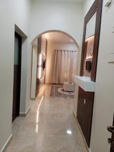 a hallway with a mirror and a sink in a room at Al Khashabah Apartment شقة في طريق إزكي - سناو in Mukhtari‘ +2 photos
