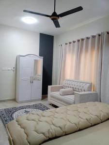 a living room with a bed and a couch at Al Khashabah Apartment شقة في طريق إزكي - سناو in Mukhtari‘
