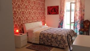 a bedroom with a bed and a red wall at Le Tre Rose Bed & Breakfast in Casamassima