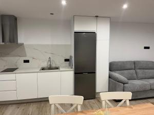 a kitchen with a refrigerator and a couch at Apartamentos HORNOS in Hornos