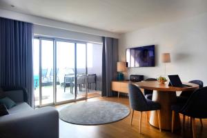 a living room with a table and a living room with a view at Feel So Good Apartment with Sea View Hot Tub in Sesimbra