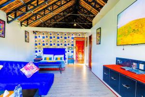 a living room with a blue couch and a tv at Kitumo Mara Lodges in Mara Simba