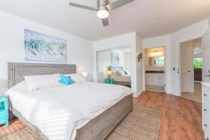 a bedroom with a large bed with a ceiling fan at Emmalani Court 423 in Princeville +23 photos