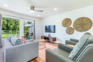 a living room with two couches and a table at Emmalani Court 423 in Princeville