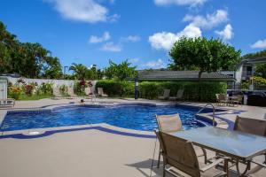 a swimming pool with a table and chairs in a yard at Emmalani Court 423 in Princeville