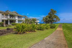 a house with a tree and a dirt road at Emmalani Court 423 in Princeville