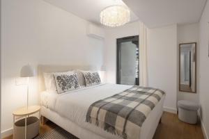 a white bedroom with a large bed and a chandelier at With pool in Funchal - Acqua Residence V in Funchal