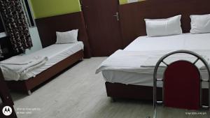 two beds in a small room with two bedsskirts at HOTEL OASIS PALACE in Dālkola +8 photos