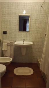 a bathroom with a sink and a toilet and a mirror at Villa Apollonia B&B in Monopoli +5 photos