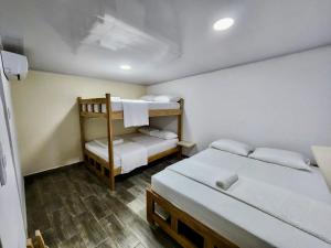 a room with two beds and a bunk bed at Hotel Casablanca in Galapa