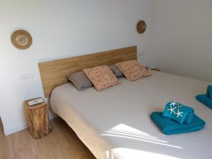 a bedroom with a large white bed with blue pillows at Séjour cosy proche mer- la Torche- spot surf in Penmarcʼh