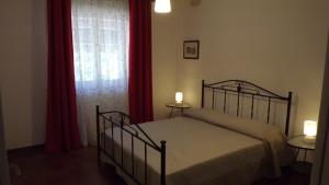 a bedroom with a bed and a window with red curtains at Villa Apollonia B&B in Monopoli