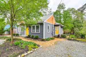 a small house with a yellow door in a yard at Renovated Carrboro House with Deck and Fire Pit! in Carrboro