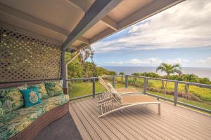 a balcony with a couch and the ocean at Hale Hamakua in Papaaloa