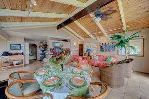 a dining room and living room with a table and chairs at Hale Hamakua in Papaaloa