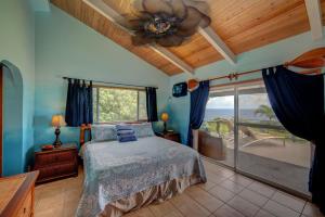 a bedroom with a bed and a ceiling fan at Hale Hamakua in Papaaloa