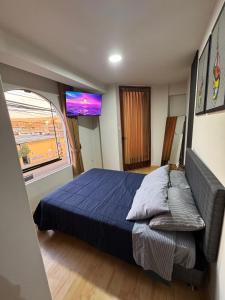 a bedroom with a bed and a large window at Solena Apartamentos Tacna in Tacna