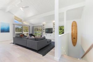 a living room with a couch and a surfboard on the wall at Hale Mauna Nui in Princeville