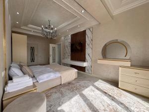 a bedroom with a large bed and a chandelier at Samarkand Premium Apartment in Samarkand