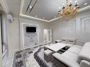 a living room with a couch and a chandelier at Samarkand Premium Apartment in Samarkand