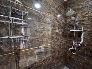 a bathroom with a shower with a stone wall at Samarkand Premium Apartment in Samarkand +26 photos