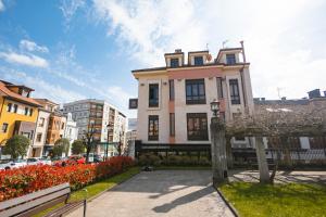 a building on a city street with flowers in front of it at Hotel Boutique Villa de Noreña in Noreña