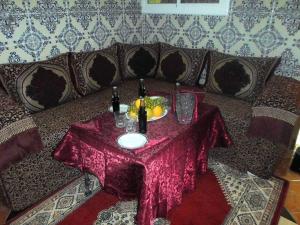 a table with drinks and fruit on a couch at Maison d'hôtes de Zaida in Zeïda