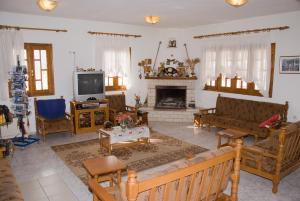 a living room filled with furniture and a tv at Guesthouse Arsenis in Kalabaka
