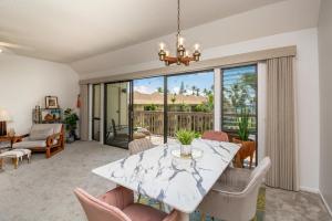 a dining room with a marble table and chairs at Lae Nani 434 in Kapaa