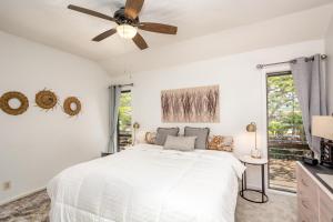 a bedroom with a white bed and a ceiling fan at Lae Nani 434 in Kapaa +23 photos