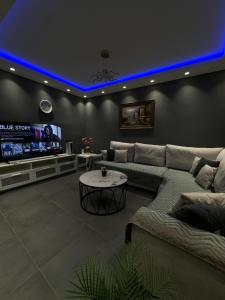 a living room with a couch and a tv at Johns villa in Artemida