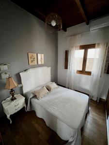a bedroom with a white bed and a window at Finca La Marquesa - Cuenca in Valera de Abajo