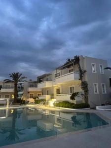 a large apartment building with a swimming pool at night at Ninemia Beach Hotel & Suites in Agia Marina Nea Kydonias