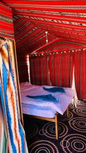 ワディ・ラムにあるWadi Rum Spiritの赤い天井のドミトリールームのベッド1台分です。