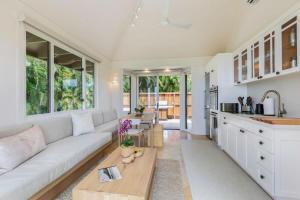 a living room with a white couch and a table at Hale Nanea in Kilauea