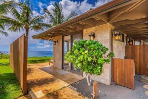 a house with a tree in front of it at Hale Nanea in Kilauea +16 photos