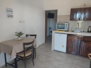 Una pequeña cocina con una mesa y un microondas. en El Tata, en Recreo 17 fotos más