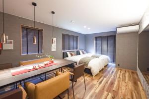 a bedroom with a bed and a table and chairs at Higashiyama bau in Kanazawa